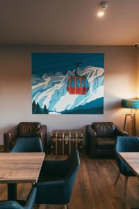 a room with couches and a painting of a ski lift at Hotel Arena Maribor in Maribor