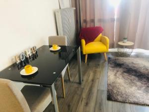 un salon avec une table noire et une chaise jaune dans l'établissement Happy studio 64 St louis, à Saint-Louis