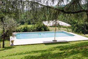 einen Pool im Garten mit Sonnenschirm in der Unterkunft Villa di Leonardo in Sinalunga