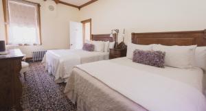 a hotel room with two beds and a desk at Teller House in Silverton
