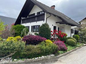 a white house with flowers in front of it at Pleasant Apartments in Bled