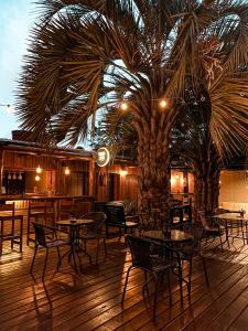 a restaurant with tables and chairs and a palm tree at RocaMar Hostel Boutique in Punta del Este