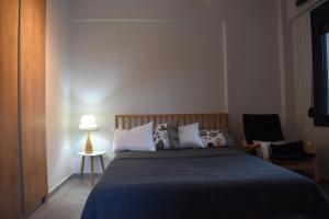 een slaapkamer met een bed, een lamp en een stoel bij Studio2 in Katerini in Kateríni