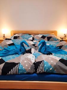 uma cama com um edredão e almofadas azuis em Apartmán Sen em Petrov