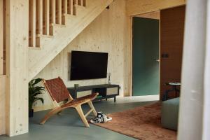 a living room with a chair and a television at Resort Brinckerduyn in Appelscha