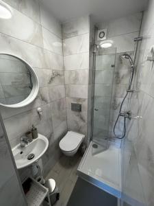 a bathroom with a shower and a toilet and a sink at Sun & Fun in Władysławowo +50 photos