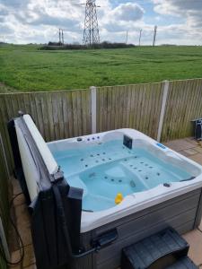 a jacuzzi tub sitting on a patio next to a fence at The Thatchie in Deal