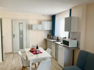 a small kitchen with a white table and chairs at Apartamenty u Lucyny i Lecha in Łukęcin