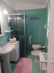 un bagno verde con due servizi igienici e una doccia di Residenza Multa Sabida a Porto Rotondo
