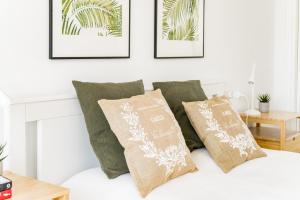 biała sypialnia z zielonymi poduszkami na łóżku w obiekcie Cozy 2 Bedroom Apartment in Nueva Andalucia w Marbelli