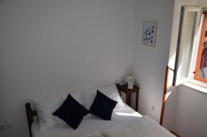 een wit bed met zwarte kussens in een kamer bij DoLa Split in Split