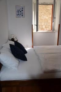 een slaapkamer met 2 bedden met kussens en een raam bij DoLa Split in Split