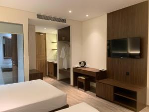 a hotel room with a bed and a television at Win Condotel Apec Phú Yên in Tuy Hoa