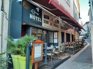 a restaurant with tables and chairs on a street at Hôtel Le Passage de Vallon in Vallon-Pont-dʼArc