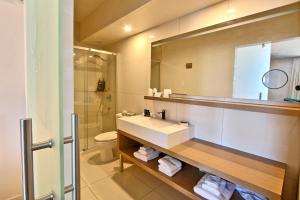 La salle de bains est pourvue d'un lavabo, de toilettes et d'un miroir. dans l'établissement Hôtel Le Navigateur, à Rimouski