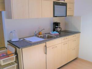 eine kleine Küche mit einer Spüle und einer Mikrowelle in der Unterkunft Oeystrasse 10a in Adelboden