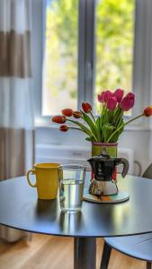 un tavolo con due tazze e un vaso con dei fiori sopra di Beatrix House a Roma