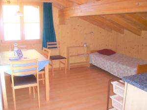 a room with a table and a bed and a desk at Oeystrasse 10a in Adelboden
