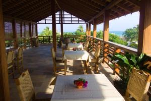 a restaurant with tables and chairs on a balcony at Hotel Otsunami in Lomé