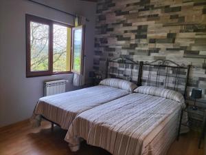a bedroom with a bed and a brick wall at Apartamentos La Corona in Parres de Llanes