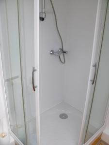 a shower with a glass door with a shower head at Hôtel Le Vivier WISSANT - Rivière in Wissant