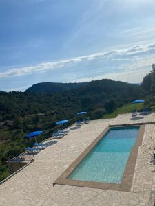 a swimming pool with chairs and umbrellas on a mountain at Agroturismo Finca Can Sec, SL in Lloseta