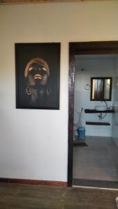 a bathroom with a picture of a face on the wall at Chalé Suite do chá in Lavras Novas