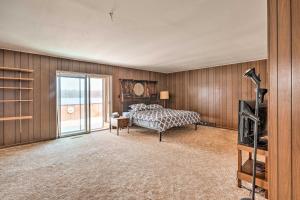 una camera con un letto in una stanza con pareti in legno di Cozy Home with Yard Steps to Mississippi River 