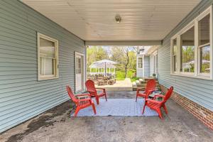 a porch with red chairs and a table and a patio at Chic Nashville-Area Retreat with Private Pool! in Kingston Springs