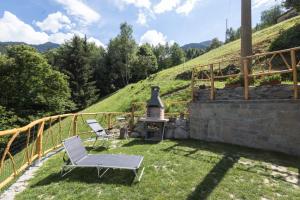a patio with a chair and a stove on a hill at Casa Vacanza Ca' de l'elmo in Castello dellʼAcqua