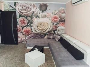 a wall mural of pink roses in a room at Palma in Burgas City