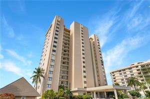 a large building with palm trees in front of it at The Sea-Winds Condo I Renovated Beachfront 2 Bed 2 Bath Condo in Marco Island
