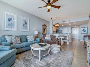 a living room with a blue couch and a table at The Beach Club Doral 306 - Spacious Beachfront Condo! in Gulf Shores