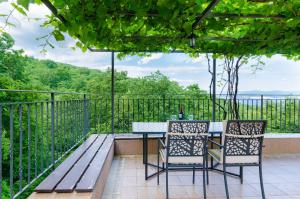 een patio met een tafel en stoelen op een balkon bij Apartments Marijana in Ičići