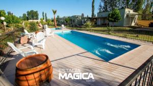 una piscina con sillas y un barril junto a una casa en Cabañas en Cuadro Nacional en San Rafael