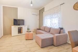 a living room with a couch and a tv at House Roko and Karla in Kali
