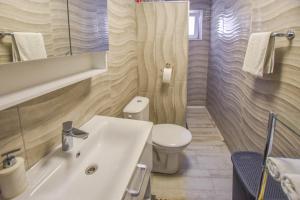 a bathroom with a white sink and a toilet at House Roko and Karla in Kali +24 photos