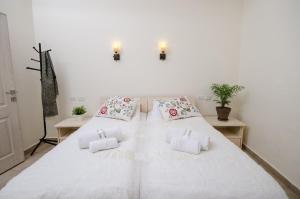 um quarto branco com uma grande cama branca com almofadas em The Spirit Of Tzfat Villa em Safed