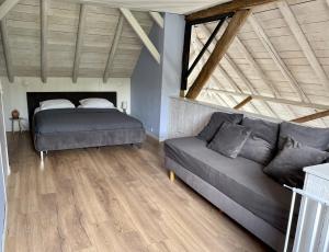 een woonkamer met een bed en een bank bij B&B Woudzicht in Oudeschoot