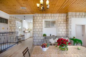 sala de estar con sofá y mesa con flores en The Spirit Of Tzfat Villa, en Safed