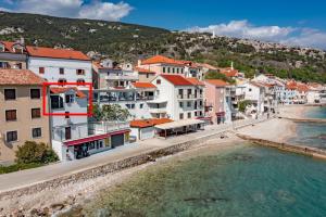 a group of buildings on a beach next to the water at Seafront Baska Apartment in Baška