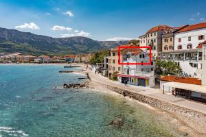 a view of a beach with buildings and the water at Seafront Baska Apartment in Baška