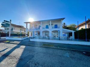米薩諾阿德里亞蒂科的住宿－Hotel Ca' Bianca da Paolino，白色的建筑,设有蓝色的阳台,位于街道上