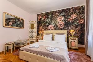 - une chambre avec un grand lit et un mur fleuri dans l'établissement Historical GuestHouse, à Braşov