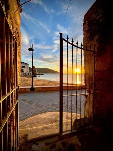 un cancello aperto con un tramonto dietro di esso di Palazzo Coccoli a Santa Maria di Castellabate