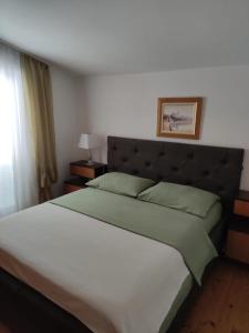 a bedroom with a large bed with a headboard at Apartment Gallery in Kaštela