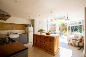 a kitchen with a refrigerator and a stove top oven at Gleneda Cottage - a renovated, traditional Cotswold cottage full of charm with fireplace and garden in Bourton on the Hill
