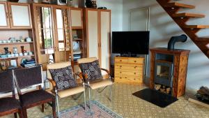 a living room with two chairs and a television at Fenyves Villa in Balatonakarattya