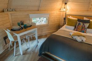 1 dormitorio con cama, mesa y escritorio en Punch Tree Cabins Couples Outdoor Bath en Carluke