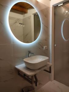 een badkamer met een wastafel en een ronde spiegel bij Sant Efisio Host in Cagliari